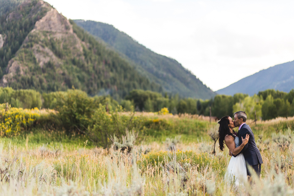 bride groom kissing in front of mountains in aspen colorado wedding