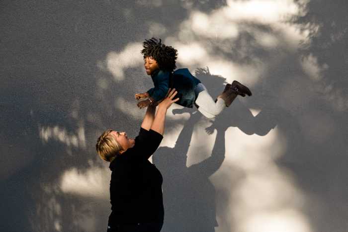 Mother throwing child in the air at family photos